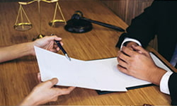 A man and woman at a desk, focused on writing notes